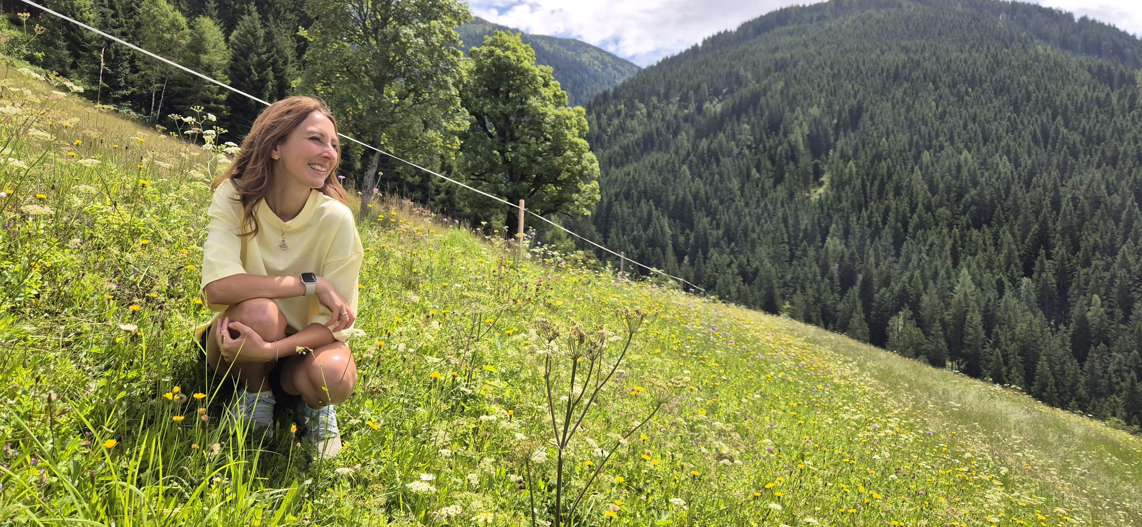 Alex auf einer Blumenwiese in den Bergen